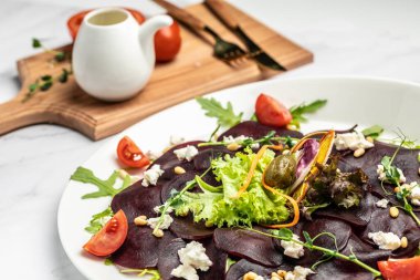 Feta, roka ve zeytinyağlı pancar carpaccio. İtalyan mutfağı. Lezzetli kahvaltı ya da atıştırmalık, temiz yemek, diyet, vejetaryen yemek konsepti. en üstteki görünüm.