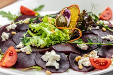 Feta, roka ve zeytinyağlı pancar carpaccio. İtalyan mutfağı. Yemek tarifi geçmişi. Kapat..