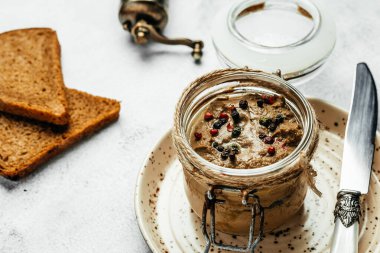 Cam kavanozda ev yapımı sığır ciğeri ezmesi ve baget dilimleri, lezzetli bir kahvaltı veya atıştırmalık.,