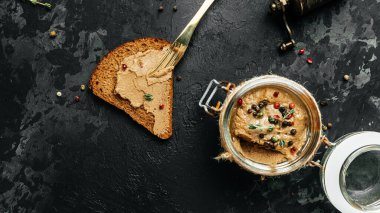 Karaciğer ezmeli kızarmış ekmek. Cam kavanozda ev yapımı tavuk ciğeri ezmesi. Mutfağa koşun. Uzun afiş biçimi. en üstteki görünüm.