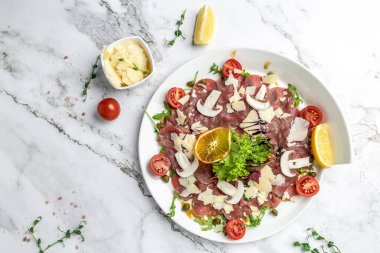 Parmesanlı sığır eti, kapari ve roka. Soğuk meze. afiş, menü, metin için tarif yeri, üst görünüm