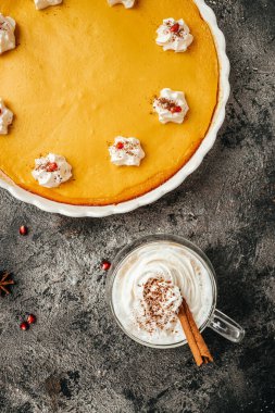 Krem şanti ve latte ile süslenmiş ev yapımı balkabaklı peynirli kek. dikey görüntü. Üst Manzara. metin için yer.