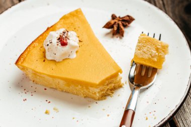 Krem şantili bir dilim balkabaklı cheesecake turtası, yemek tarifi geçmişi. Kapat..