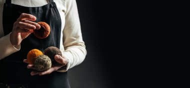 Peynir üreticisi, Belper Knolle peynirini küçük toplar şeklinde kontrol ediyor. Sert peynir tutan kadın elleri. Uzun pankart biçimi.