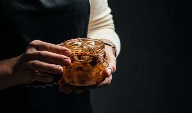 Peynirci ellerinin yağda marine edilmiş peynirli bir kavanozu var. Ekoloji ve eko-ürünler, lezzetli ve sağlıklı yiyecekler. afiş, menü, metin için tarif yeri.