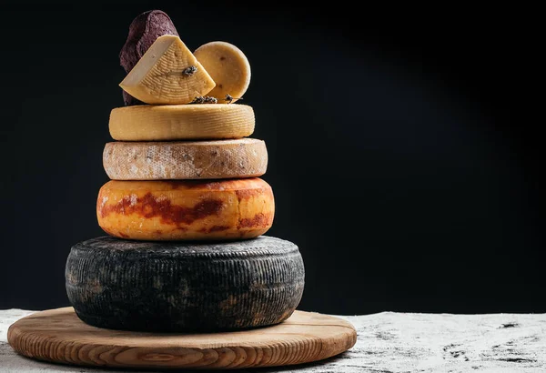 stock image variation of hard and semi-hard cheese on dark background. Petit Basque, French cheese, spanish manchego cheese.