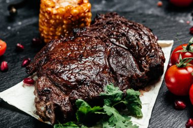 Koyu arkaplanda ızgara biftek. Restoran menüsü, diyet, yemek kitabı tarifi üst görünümü.