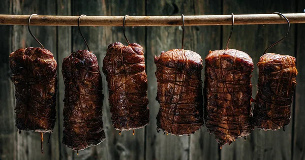 Smoked ham, bacon, pork in a smokehouse. Traditional method of smoking meat in smoke. banner, menu, recipe place for text.