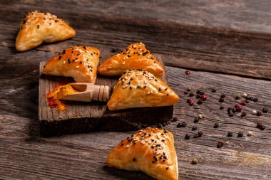 Geleneksel Hint mutfağı samosaları, lezzetli hamur işleriyle pişirilmiş hamur işleri, kırsal arka planda baharatlı popüler Hint atıştırmalıkları, üst manzara.