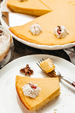 Pumpkin pie, tart pie for Thanksgiving day with whipped cream and latte. vertical image. top view. place for text.