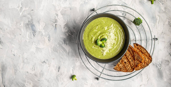 Fresh broccoli soup on bowl on light background. Long banner format. Vegetarian and diet food.