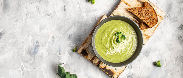 Traditional recipe of broccoli cheese soup with vegetables in a bowl with toast, homemade healthy organic vegetarian vegan diet fresh food meal dish soup lunch, space for text. top view.