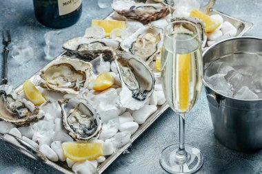 Oysters with wine, lemon, and ice. oysters dish. Oyster dinner with champagne in restaurant. banner, menu, recipe place for text, top view. clipart