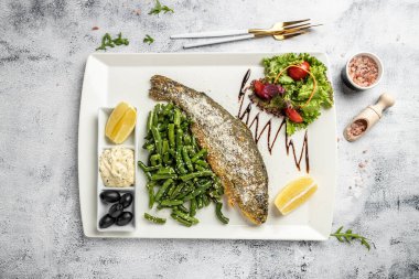 Parmesanlı, limonlu ve sebzeli kızarmış balık. Restoran menüsü, diyet, yemek kitabı tarifi. en üstteki görünüm.