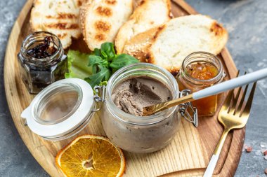 Tahta bir tahtanın üzerinde beyaz ekmek parçalarıyla ördek ciğeri ezmesi. Gurme aperatifler, çeşitli İtalyan aperatifleri bruschetta.
