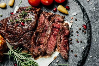 Dilimlenmiş biftek, arka planda ızgara. Restoran menüsü, diyet, yemek kitabı tarifi üst görünümü.