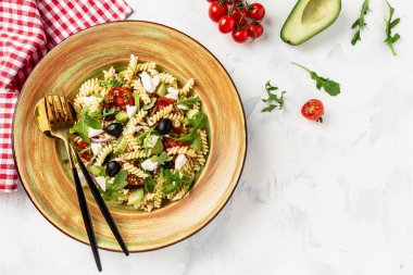 Domates, avokado, siyah zeytin, kırmızı soğan ve peynirli makarna. afiş, menü, metin için tarif yeri, üst görünüm,