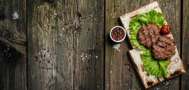 Domuz Burger doğrama tahtasında. Barbekü ızgarasında biftek. Uzun afiş biçimi. en üstteki görünüm.