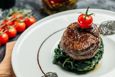 Kırmızı eti ıspanaklı, restoran menüsünde, diyette, yemek kitabı tarifinde göstermek için dilimlenmiş orta pişmiş biftek fileto.,