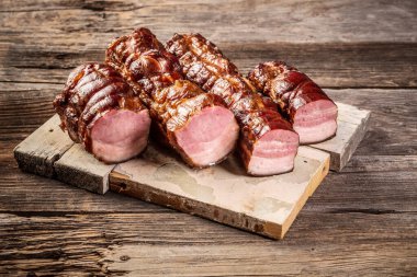 Lezzetli zanaatkar tütsülenmiş domuz pastırması. Geleneksel olarak ahşap tahtada tütsülenmiş et. Kırsal tarzda. pankart menü tarifi.