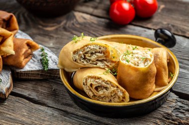 Lezzetli krep ruloları, içi et dolu doldurulmuş krepler. Geleneksel Rus Maslenitsa festivali yemeği ahşap arka planda.