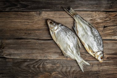 Güneşte kurutulmuş balık. Kahverengi ahşap masada stok balığı. Bira fabrikası konsepti. Kurutulmuş bira için atıştırmalık. Bira arkaplanı,