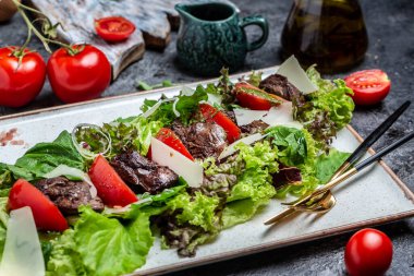 Tavuk ciğeri ve salata yaprakları, parmesan peyniri ve vişneli domates. Lezzetli dengeli gıda konsepti.