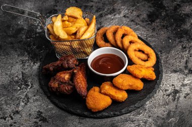 Kızarmış tavuk, patates kızartması ve nugget, abur cubur ve sağlıksız yemek, lezzetli bar tarzı, aperatif, restoran menüsü, üst manzara.,