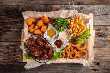 Kızarmış tavuk, patates kızartması ve nugget, abur cubur ve sağlıksız yemek, lezzetli bar tarzı, aperatif, restoran menüsü, üst manzara.,