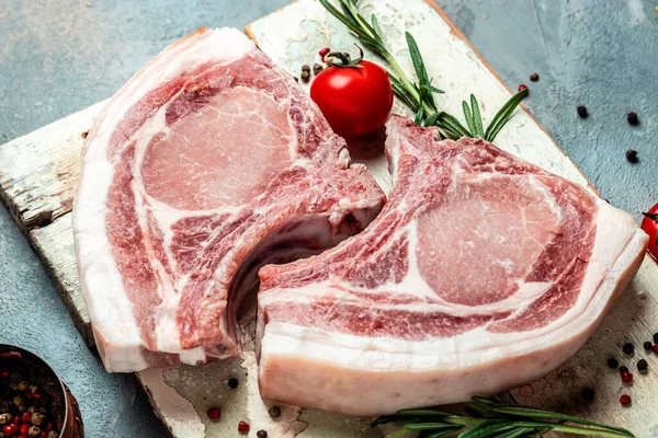 Çiğ domuz pirzolası. Organik yiyecekler. dikey görüntü. Üst Manzara. metin için yer.