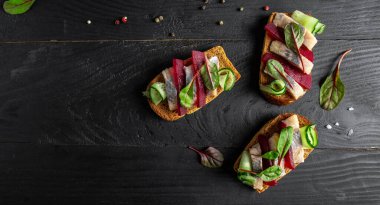 Ringa filetosu. Tuzlu ringa balıklı sandviç, pancar kökü, yeşil salatalık, soğan ve kızarmış ekmek. İskandinav mutfağı. Geleneksel Danimarka sandviçi. en üstteki görünüm,