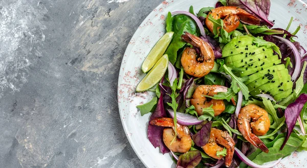 Shrimps salad, avocado, onion and smoked shrimps. Homemade vegetarian shrimp salad. Seafood concept. Tasty veg mixed leaves, grilled prawn shrimps.