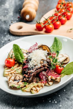 Izgara sebze, fındık, sos ve parmesanla dilimlenmiş biftek barbeküsü. İtalyan mutfağı konsepti. afiş, menü, metin için tarif yeri, üst görünüm.