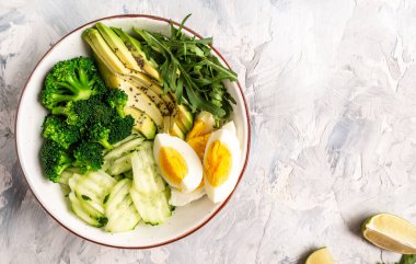 Diyet menüsü. Avokado, salatalık, brokoli ve yumurtalı sağlıklı bir yaşam. Sağlıklı organik vegan salatası. Lezzetli kahvaltı ya da atıştırmalık, temiz yemek, diyet, vejetaryen yemek konsepti. en üstteki görünüm.