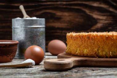 Ev yapımı sünger kek ve ahşap malzeme masası. Fırının arka plan konsepti. afiş, metin için menü tarifi yeri, üst görünüm,