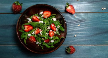 Bahar salatası, roka, çilek ve ricotta. Lezzetli kahvaltı ya da atıştırmalık, temiz yemek, diyet, vejetaryen yemek konsepti. en üstteki görünüm