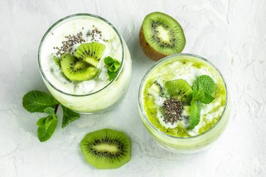 Chia pudingi, nane ve kivi. Laktozsuz yoğurt. Lezzetli kahvaltı ya da atıştırmalık, temiz yemek, diyet, vejetaryen yemek konsepti. en üstteki görünüm.