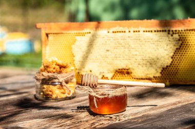 Eski köy masasında kaşığı olan doğal bal. Arı ürünleri organik doğal bileşenler konsepti, yakın çekim.