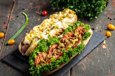 Farklı sosisli sandviçler ve koyu bir arka plan. Yemek arkaplanı. Fast food ve abur cubur konsepti, sokak yemekleri.