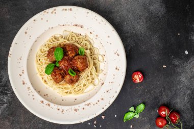 Köfteler, domates soslu İtalyan spagetti makarnası üzerine servis ediliyor. İtalyan yemeği. afiş, menü, metin için tarif yeri, üst görünüm.