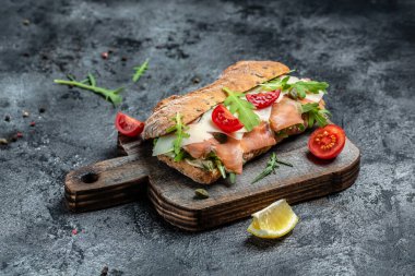 Ev yapımı ciabatta ekmekli sandviçler, tuzlu somon balığı, parmesan peyniri, kapari, vişneli domates ve roka, restoran menüsü, diyet, yemek kitabı tarifi üst görünümü,