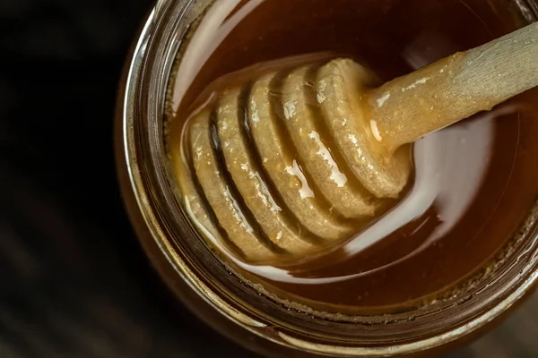 瓶の中の蜂蜜の瓶と木製のスプーン ミツバチは新鮮で健康的で蜂蜜を作り出します 蜂蜜の背景 養蜂の概念 — ストック写真