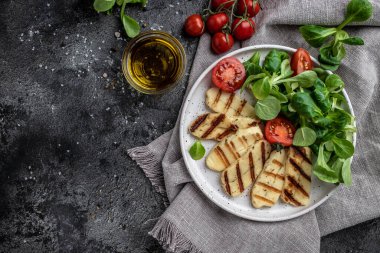 Kızarmış halloumi ve domatesli vejetaryen salatası, yakın plan ketojenik diyet. Lezzetli kahvaltı ya da atıştırmalık, temiz yemek, diyet, vejetaryen yemek konsepti. en üstteki görünüm.