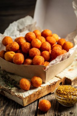 Patates kroketleri patates püresi, ekmek ve kızarmış patates topları, ahşap masada karton kutuda servis ediliyor. Amerikan gıda konsepti. Fast food yemeği. dikey görüntü. en üstteki görünüm.