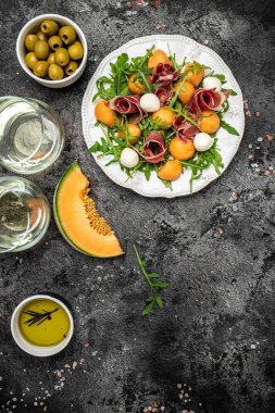 Prosciutto veya jamonlu kavun, mozzarella ve yeşil fesleğen yaprakları, geleneksel İspanyol ve İtalyan aperatifleri toptan Grissini ile servis edilir.,