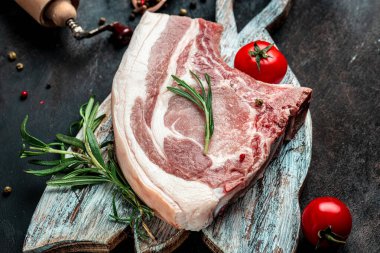 Esmer arka planda çiğ domuz pirzolası. Organik yiyecekler. afiş, menü, metin için tarif yeri.