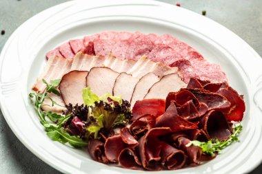 Pişmiş et tabağı dilimlenmiş jambon, sosis, jambon, jambon. Etli antipasto, pankart, menü, metin için tarif yeri, üst görünüm,