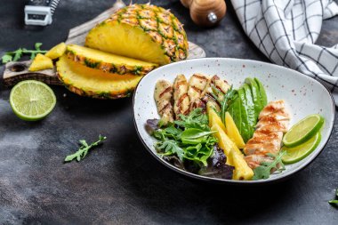 Buda kasesi, ızgara tavuk göğsü, halloumi, ananas, avokado, yeşil roket salatası, limon ve zeytinyağı. sağlıklı ve dengeli yiyecekler. afiş, metin için menü tarifi yeri, üst görünüm.