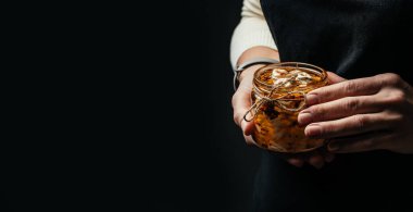 Kadın elleri, zeytinyağında peynirli cam kavanoz ve koyu aromalı otlar tutuyor. afiş, menü, metin için tarif yeri.