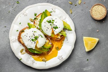Sağlıklı kahvaltı. Avokado, haşlanmış yumurta, yumuşak peynir ve kabak çekirdekli tam buğday ekmeği. Lezzetli kahvaltı ya da atıştırmalık, temiz yemek, diyet, vejetaryen yemek konsepti. en üstteki görünüm.